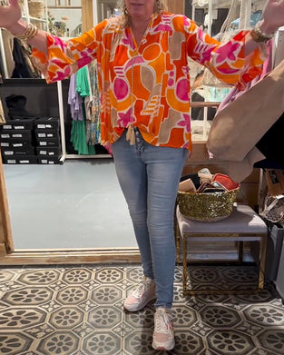 Bluse med fargerik og avløpt skulder